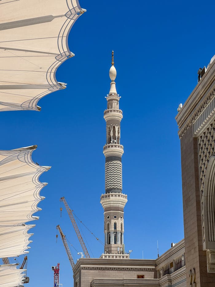 A clear view of the intricate minaret at Masjid an-Nabawi against a deep blue sky.